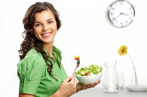 Portrait of a girl looking positive and holding a bawl with salad